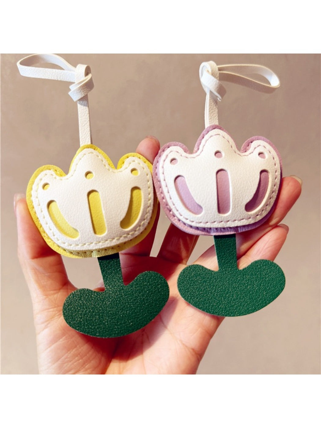 Tulip-shaped keychain hanging from a black backpack zipper