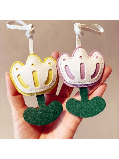 Tulip-shaped keychain hanging from a black backpack zipper
