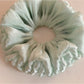 Green double layered scrunchie displayed on a white background