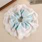 Gifty sweet printed patchwork scrunchie in natural light emphasizing fabric colors