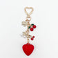 Cherry heart charm keychain held in hand showing size and detail of the charm