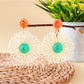Earedge raffia flower shaped drop earrings worn on a model's ear