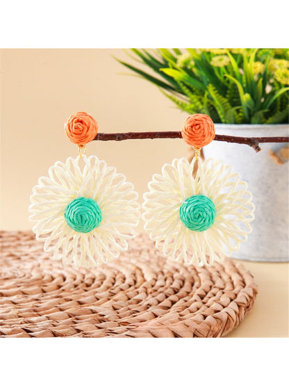 Earedge raffia flower shaped drop earrings worn on a model's ear