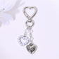 Alloy heart keychain attached to a set of keys on a wooden surface