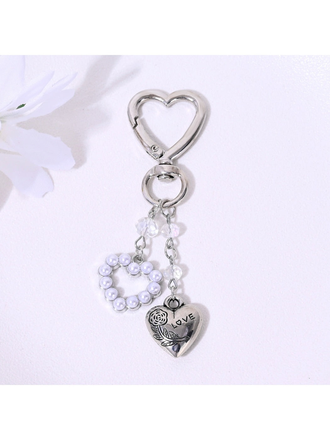 Alloy heart keychain attached to a set of keys on a wooden surface