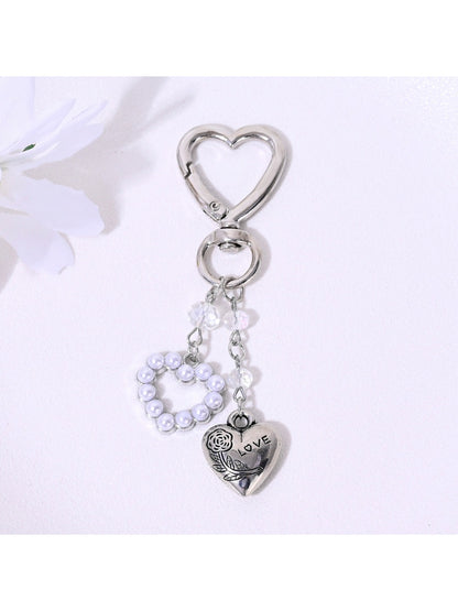 Alloy heart keychain attached to a set of keys on a wooden surface