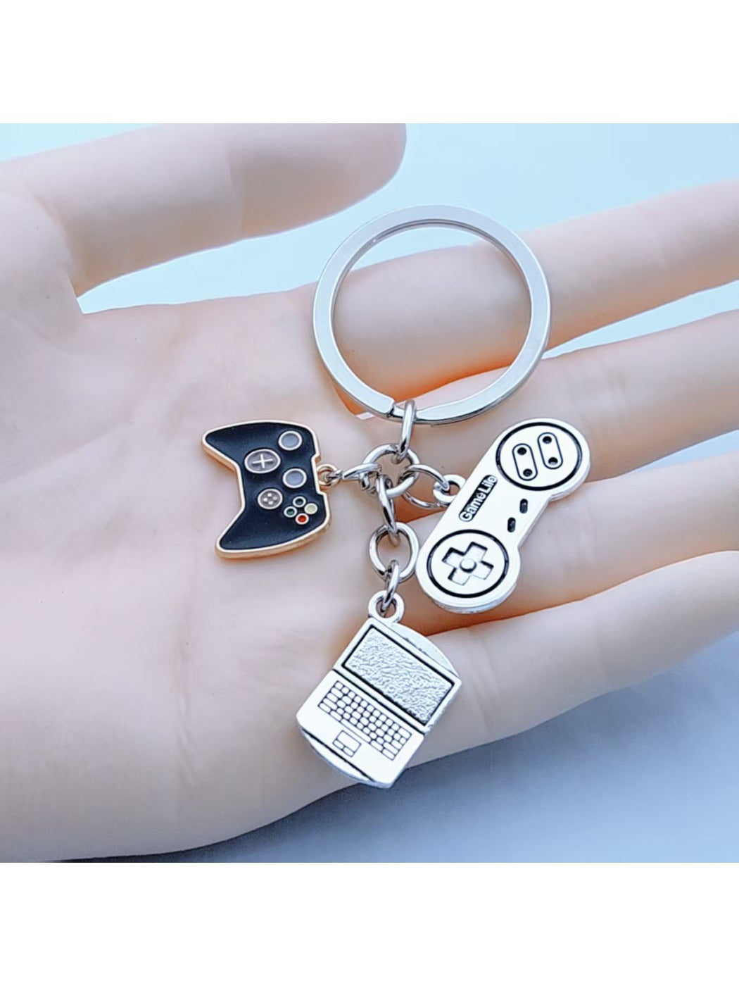Keypus game controller shaped keychain in black with colorful buttons on a white background