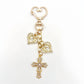 Keychain with vintage cross pendant held in a hand for scale
