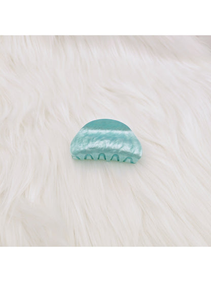 Beau claw clip resting on fabric with marble pattern details visible