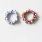 Colorful beaded hair ties stacked together highlighting the variety of colors