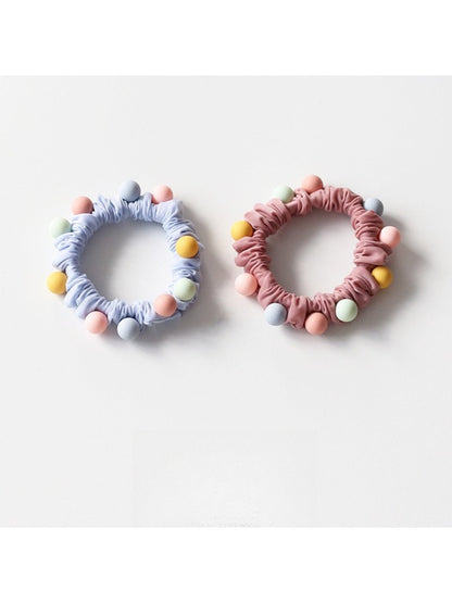 Colorful beaded hair ties stacked together highlighting the variety of colors