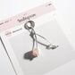 Side view of white Keypus keychain highlighting its smooth texture