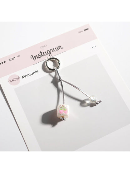 Side view of white Keypus keychain highlighting its smooth texture