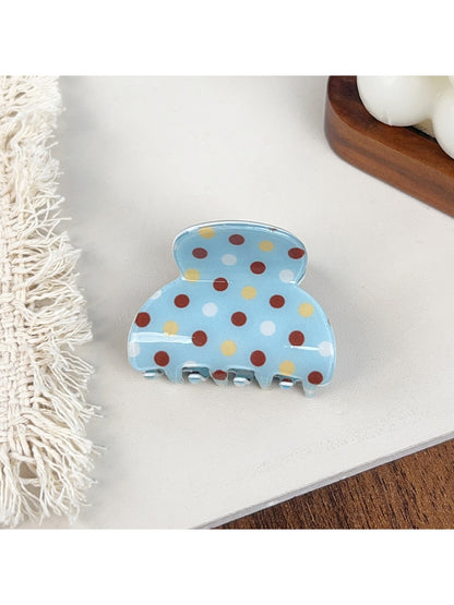 Blue polka dot hair claw clip with curved design and clasp