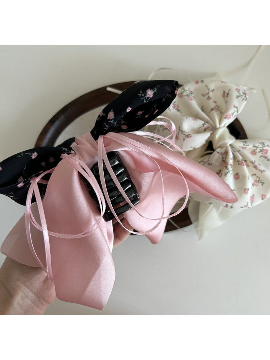 Beau Sweet Tiny Floral Bow Claw Clip held in hand showing size and detail