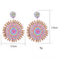 Earedge raffia round earrings displayed on a wooden surface