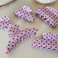 Side view of Beau pink hair clip with white polka dots and metal clasp