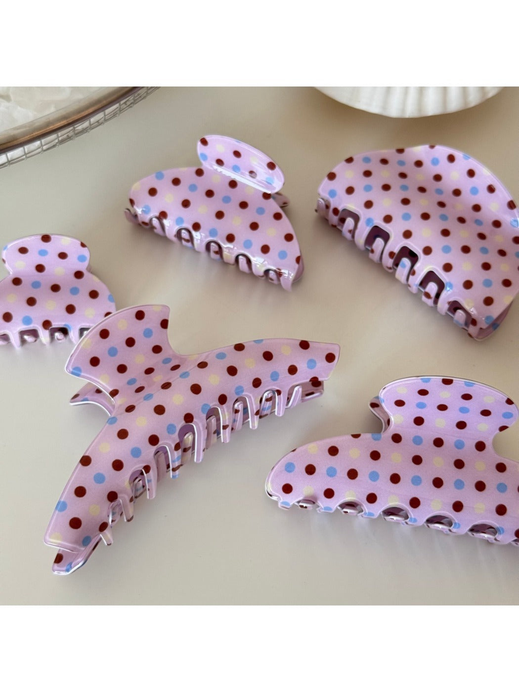 Side view of Beau pink hair clip with white polka dots and metal clasp