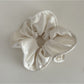 Gifty silky scrunchie stretched slightly to show elasticity and smooth fabric