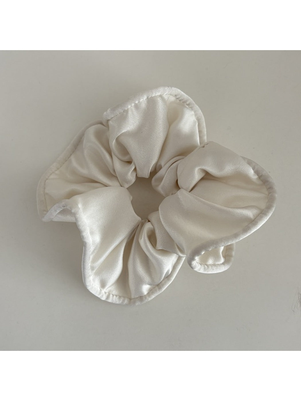 Gifty silky scrunchie stretched slightly to show elasticity and smooth fabric