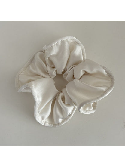 Gifty silky scrunchie stretched slightly to show elasticity and smooth fabric