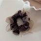 Glossy scrunchie displayed on a white background highlighting its shine