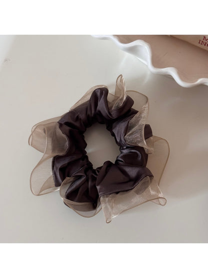 Glossy scrunchie displayed on a white background highlighting its shine