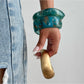 Lovra irregular textured silver bracelet worn on model's wrist with neutral outfit