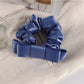 Scrunchie displayed on a white background highlighting its gentle ruffles and charm