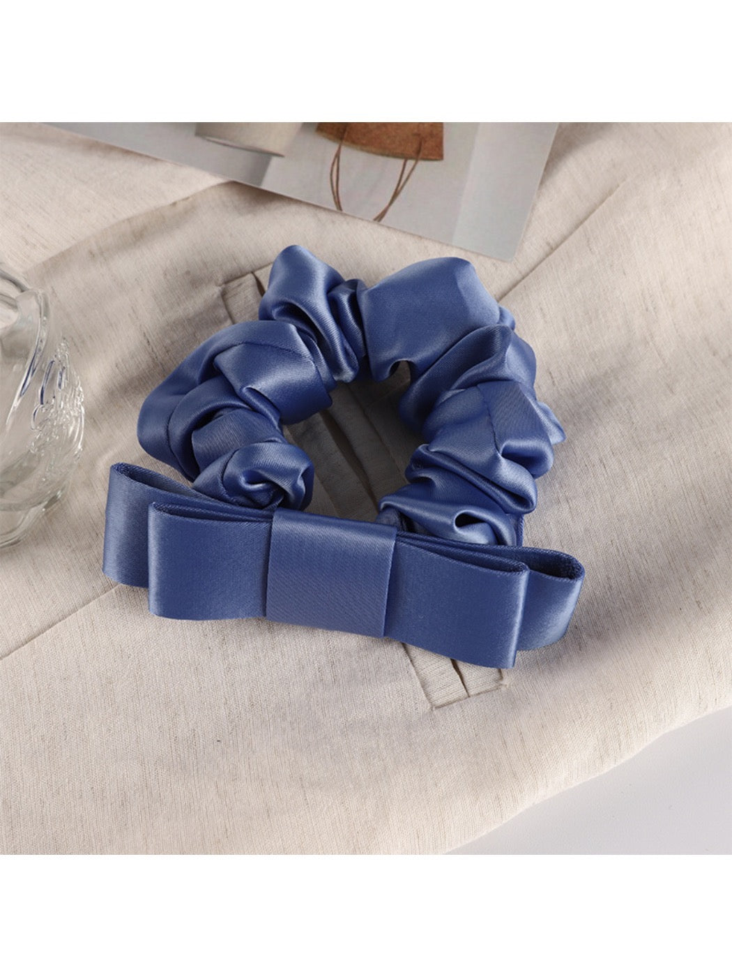Scrunchie displayed on a white background highlighting its gentle ruffles and charm