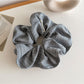 Vintage striped scrunchie wrapped around a ponytail in natural hair