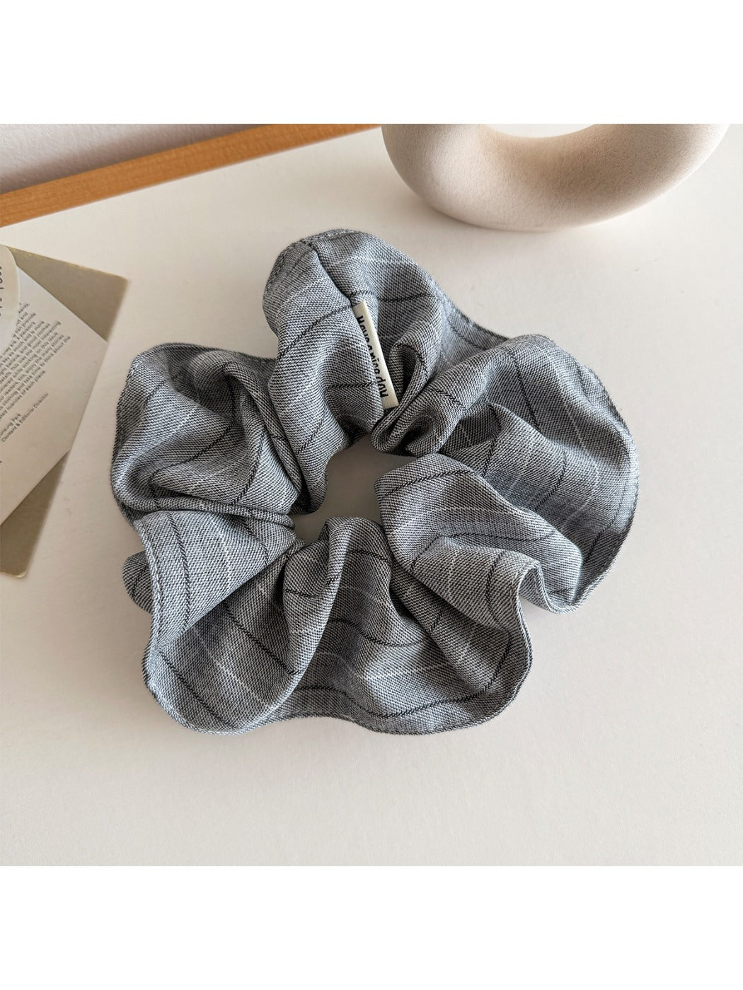 Vintage striped scrunchie wrapped around a ponytail in natural hair