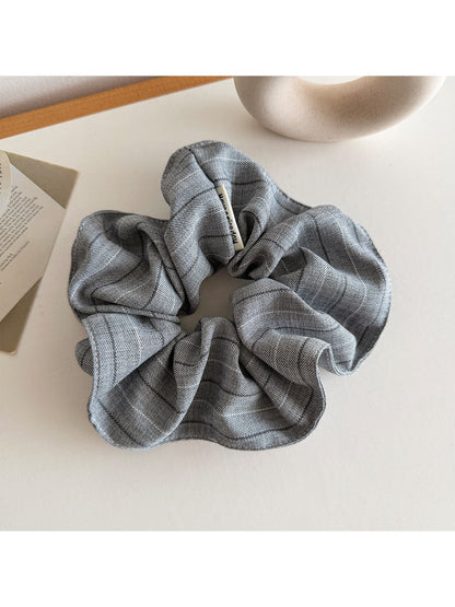Vintage striped scrunchie wrapped around a ponytail in natural hair