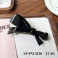 Beau bow hair clip held in hand showing size and lightweight design