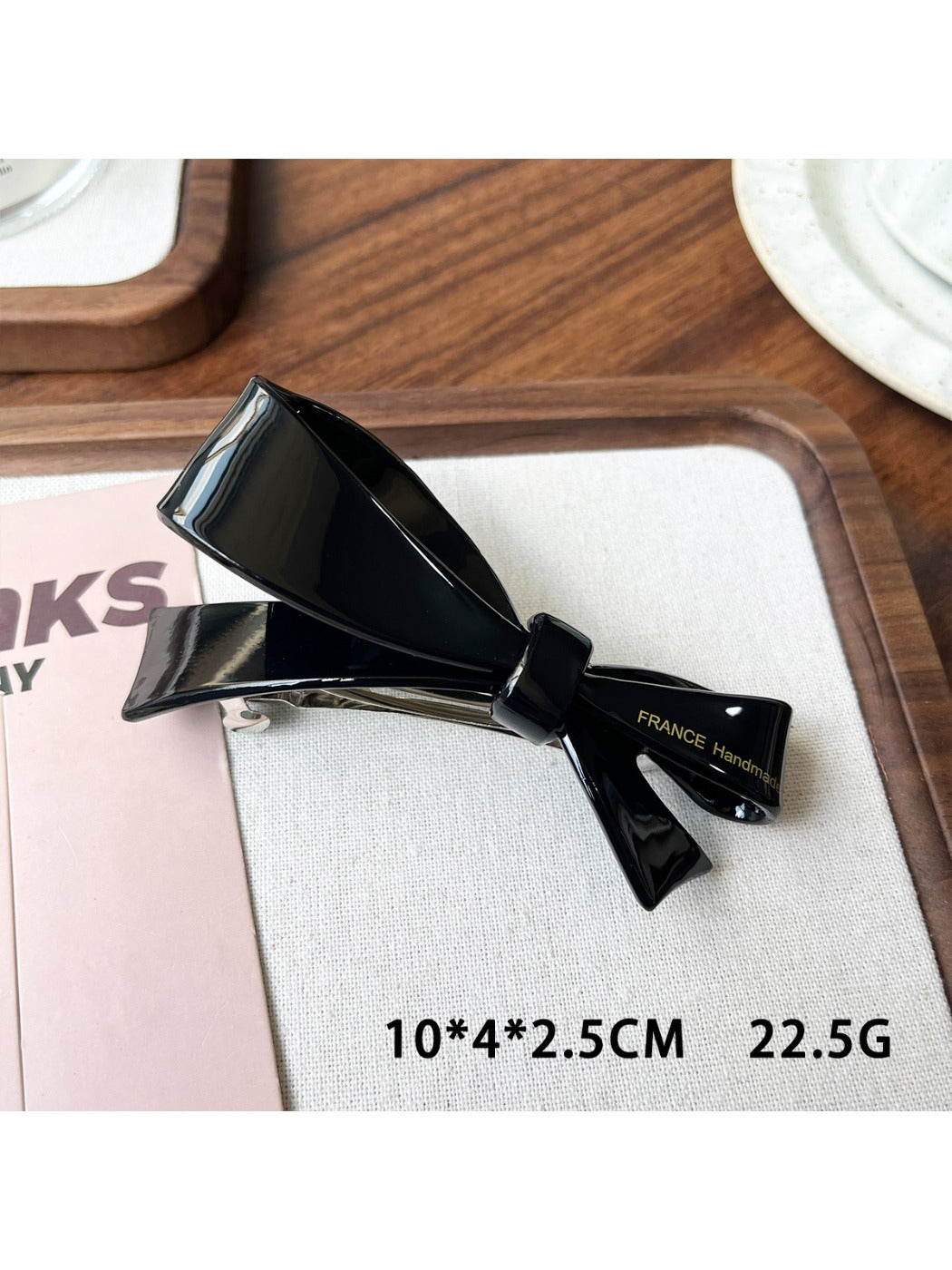 Beau bow hair clip held in hand showing size and lightweight design
