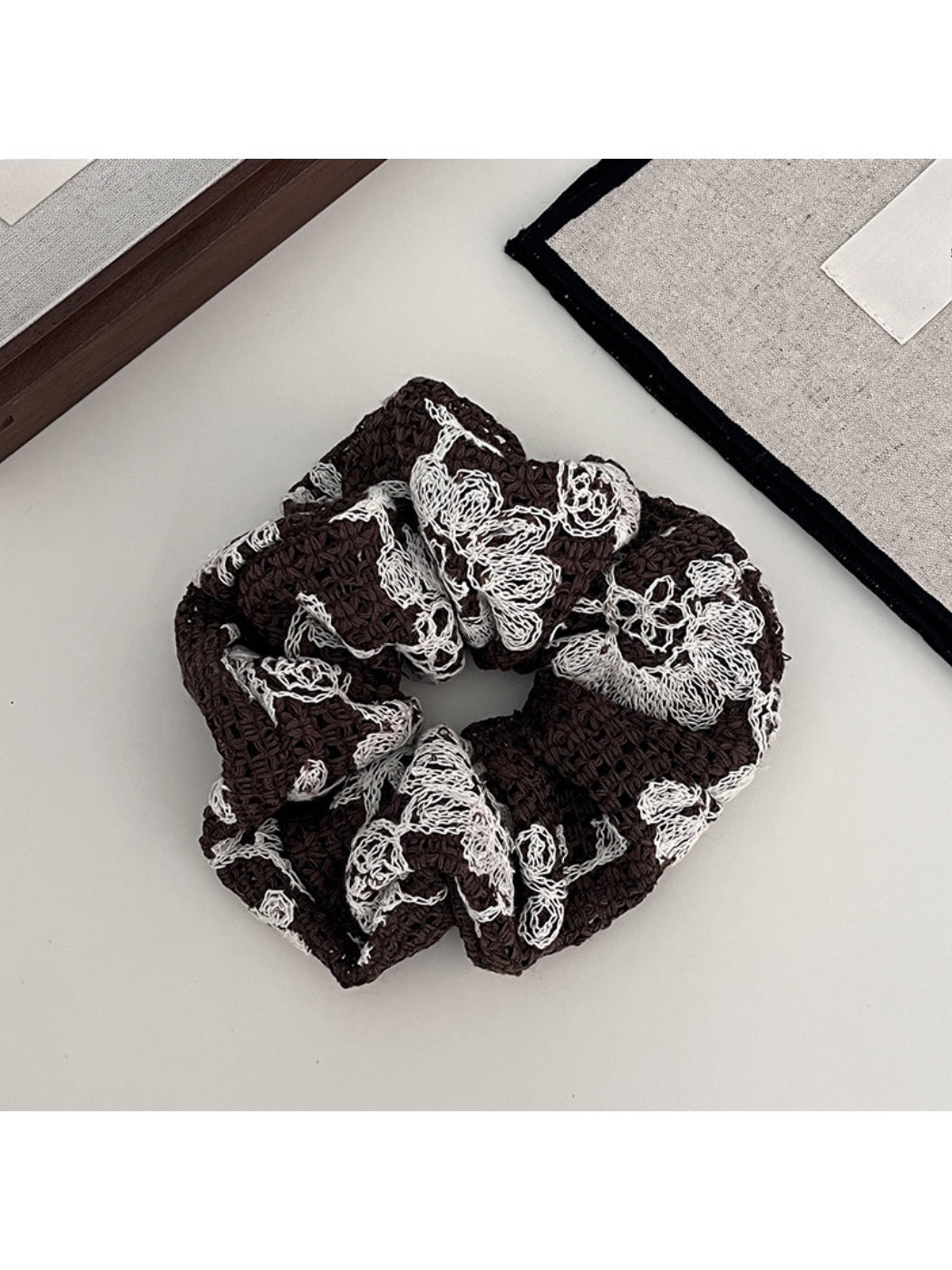 Gifty scrunchie styled with casual outfit on a wooden surface