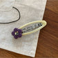 Beau flower pattern hair clip held in hand showing size and design
