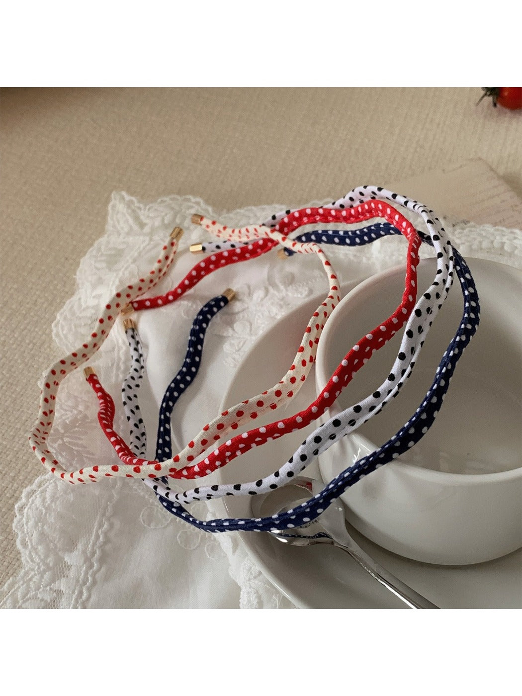 Thin wavy headband with black and white polka dot pattern on fabric