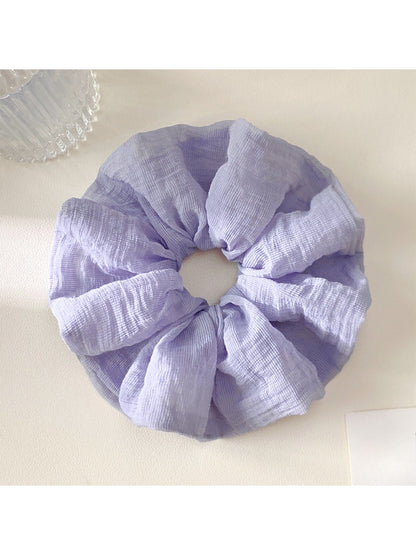 Scrunchie wrapped around a ponytail, showcasing its vibrant colors and soft fabric