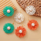 Close-up of Earedge raffia woven flower-shaped earring with natural beige fibers