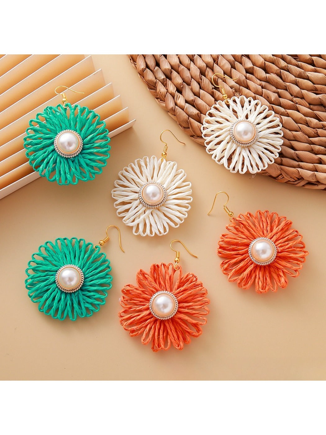 Close-up of Earedge raffia woven flower-shaped earring with natural beige fibers