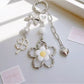 Minimalist modern flower charm keychain with silver ring on white background