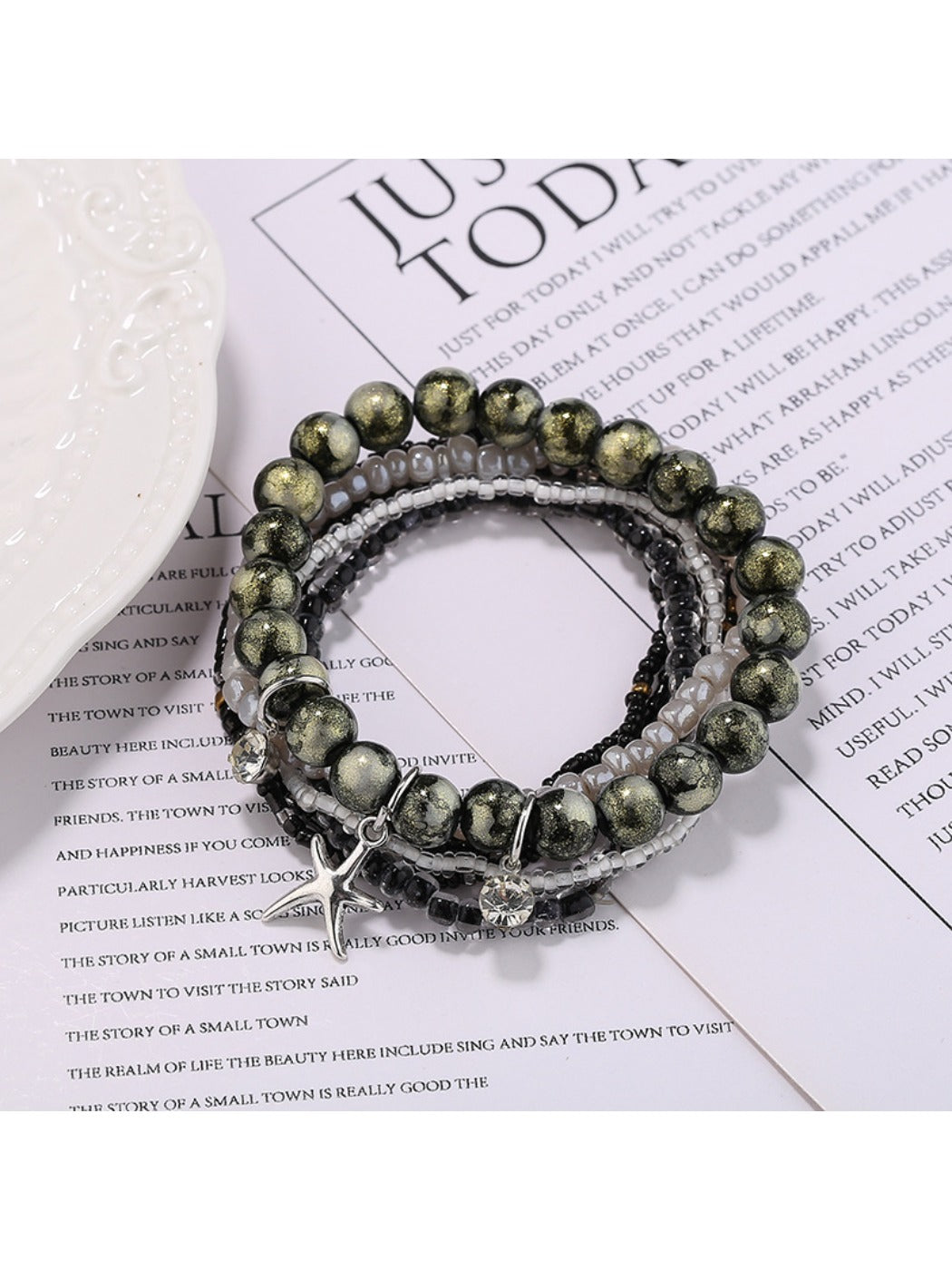 Lovra multi-row beaded bracelet with gold star pendant shown on white background