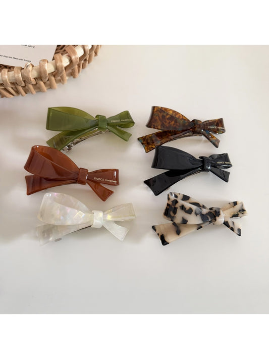 Beau irregular bow shaped hair clip in soft pink fabric on white background