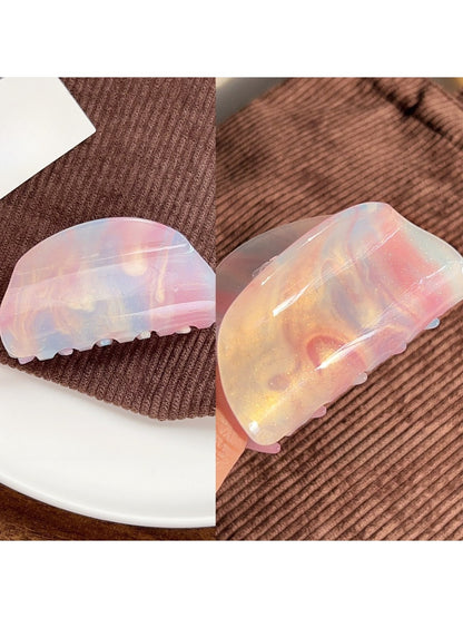 Beau colorful hair claw clip resting on fabric background