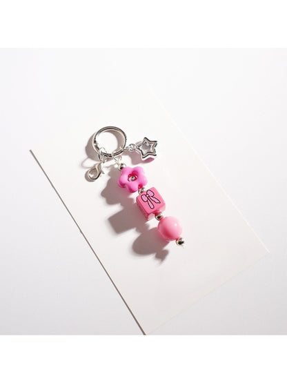 Beaded star keychain displayed with other small accessories on a table