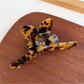 Beau hair claw clip placed next to matching minimalist accessories