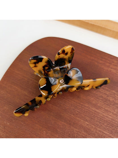 Beau hair claw clip placed next to matching minimalist accessories