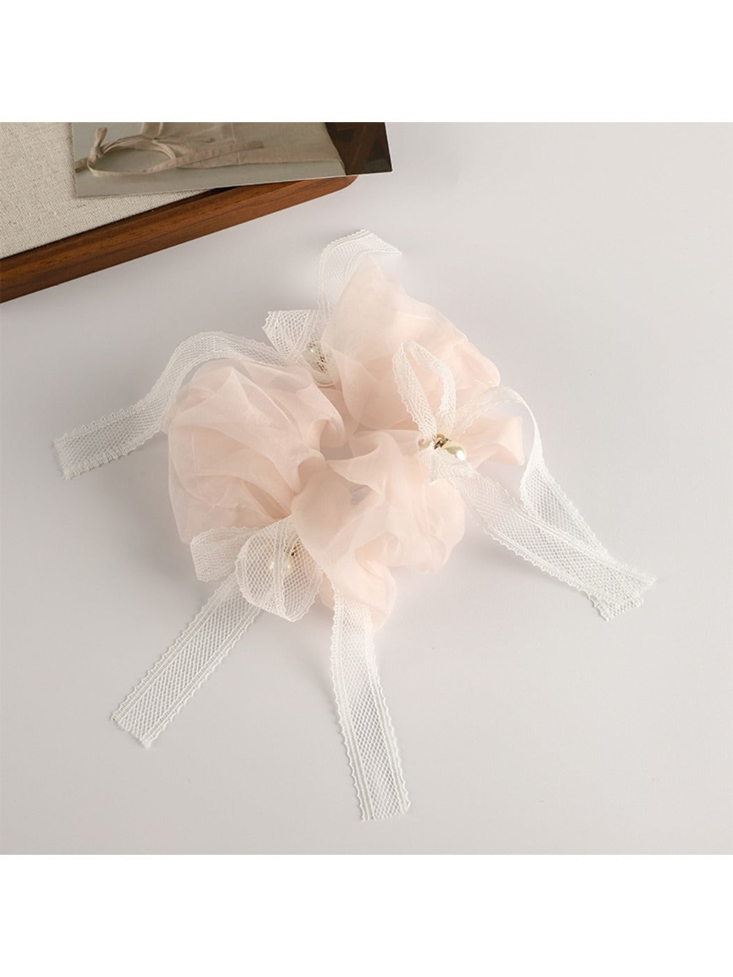 Scrunchie with bow accent wrapped around a wrist as a fashion accessory