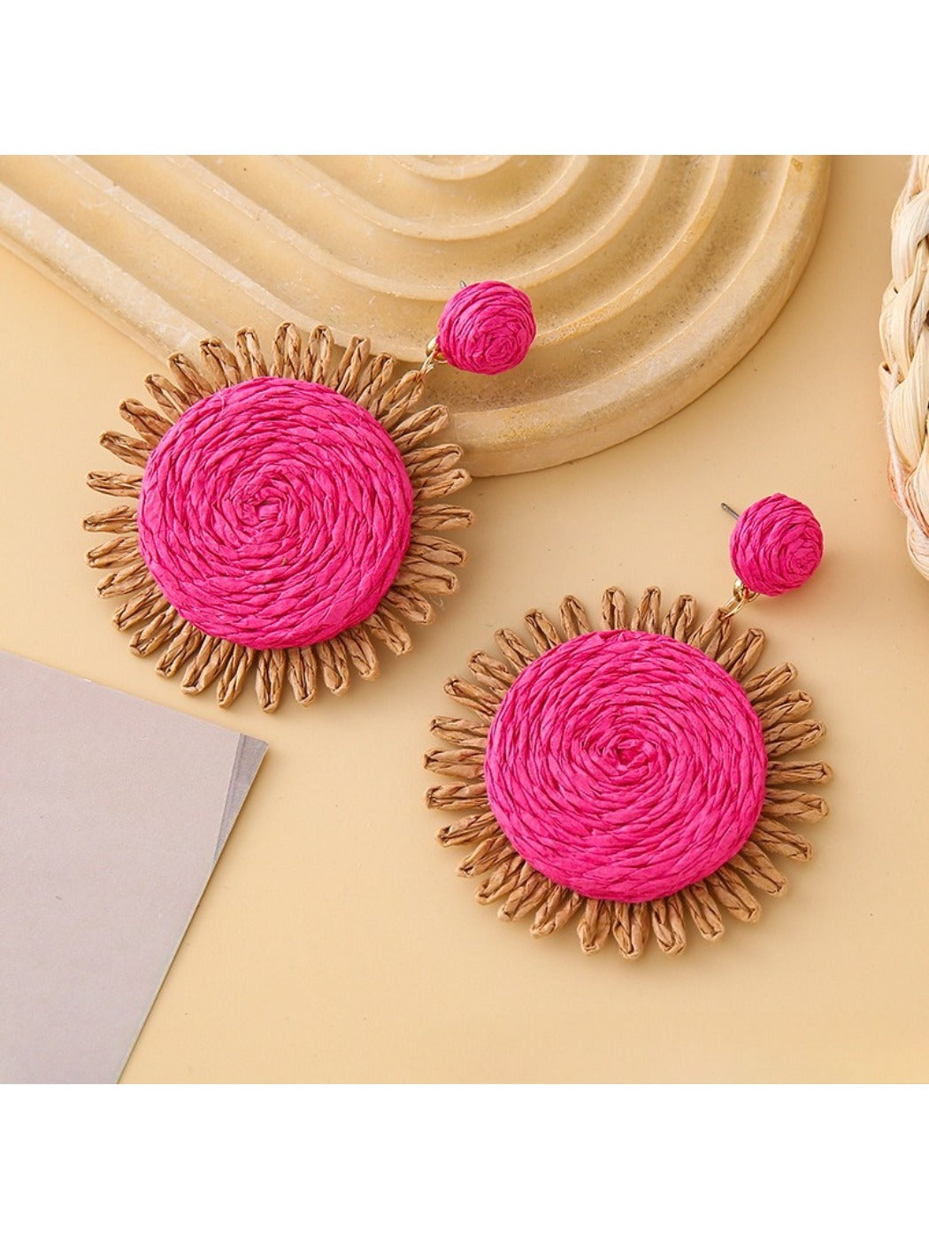 Top view of round raffia earrings highlighting intricate weaving